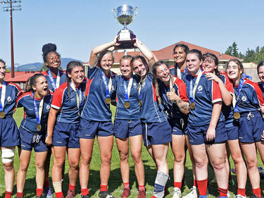 Senior Girls Rugby Team pose for photo holding trophy above their heads (Photo credit: John Morrow/Abbotsford News)