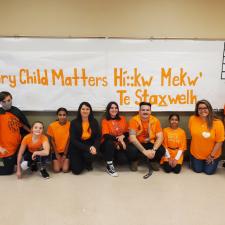 Group of students and staff wearing orange shirts