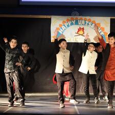 Group of students on stage performing a bhangra dance